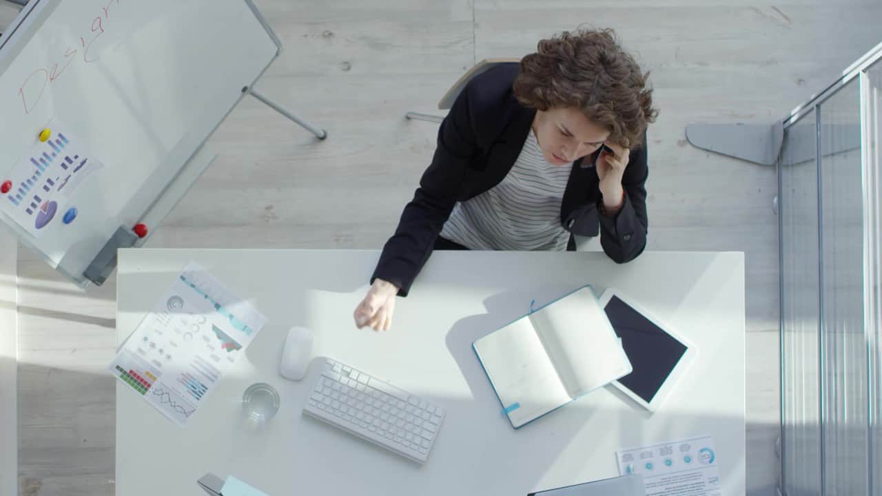 An advisor taking notes while speaking with a client on the phone